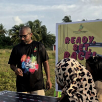 man supervising young girl play toy car race