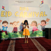little young girl singing on a stage at a carnival
