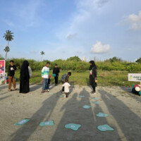 small kid taking part in "jump like a frog" jumping game