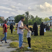 little boy asking older brother to carry him