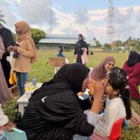 female teachers painting kids faces