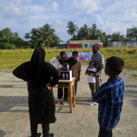 woman supervising kids playing guessing game